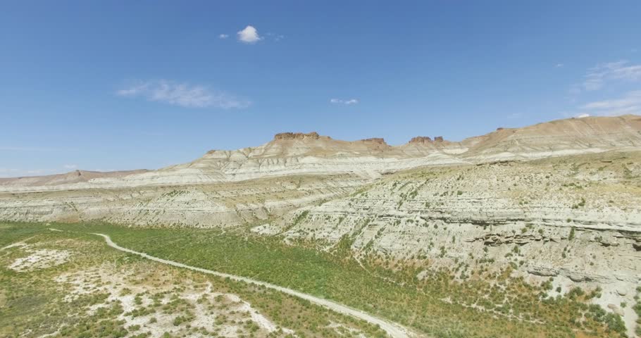 
Aerial view of desert and river environment under blue sky with clouds