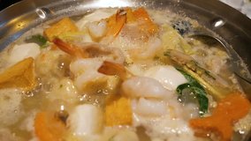 Slow motion video hot pot shabu with shrimp, fish ball and fish tofu in restaurant (High Speed Video)