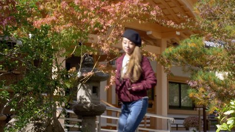 Стоковое видео: Woman walking through beautiful fall leaves in Kyoto, HD, slow motion.