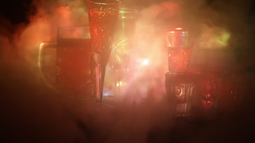 Abstract alcoholism concept. Silhouette of a man standing in the middle of the road on a misty night with giant glasses filled with alcoholic beverage. Creative artwork decoration