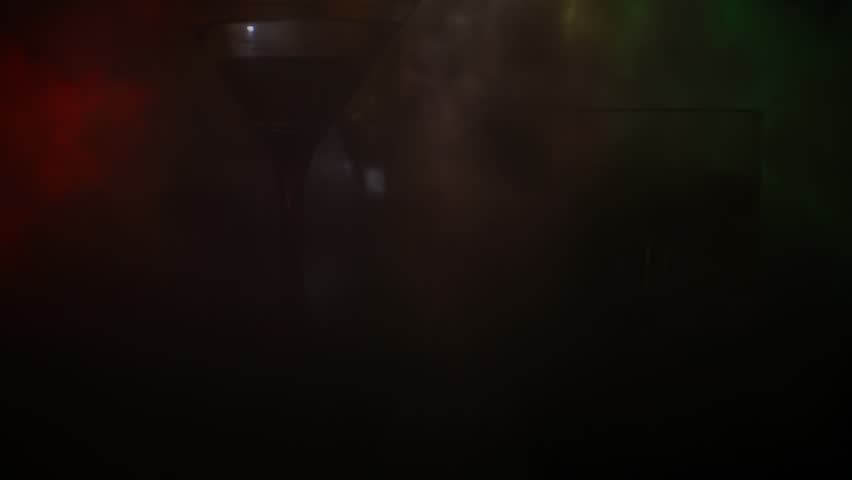 Abstract alcoholism concept. Silhouette of a man standing in the middle of the road on a misty night with giant glasses filled with alcoholic beverage. Creative artwork decoration