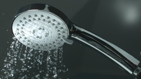 
Close up Shower head with Water Drops Splashing out and Running from Faucet in Bathroom Flowing in Slow Motion shot on High Speed Phantom Camera