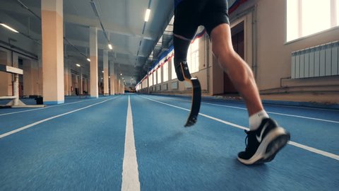 Nizhny Novgorod, Russia - CIRCA November 2018: Gym track and an athlete with a prosthetic leg running along it