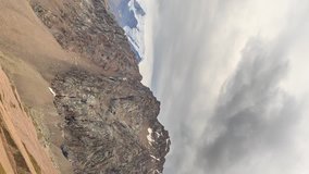 Vertical video. Clouds over snowy peaks. Talgar Pass, Chimbulak. Almaty. Kazakhstan