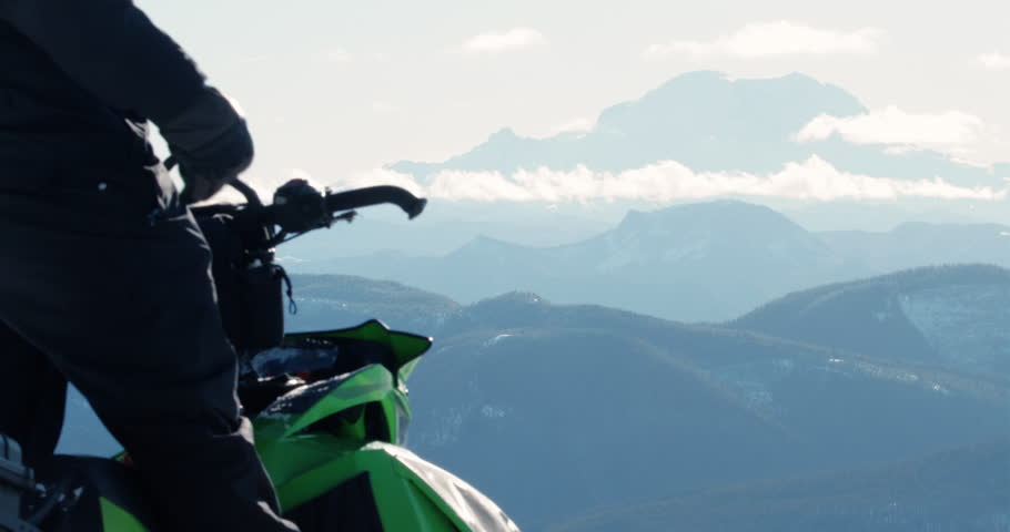 Pulling Snowmobile Start Cord to Ride Off Mt Rainier Background