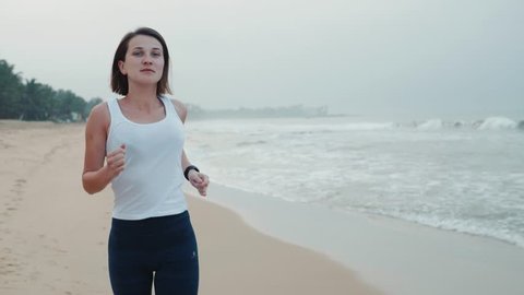sport female runner run wearing smartwatch with watchband blank black glass bent touchscreen on natural sea ocean beach background