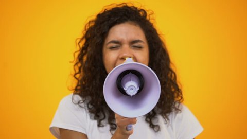 African-American woman using megaphone for protest, public opinion, politics