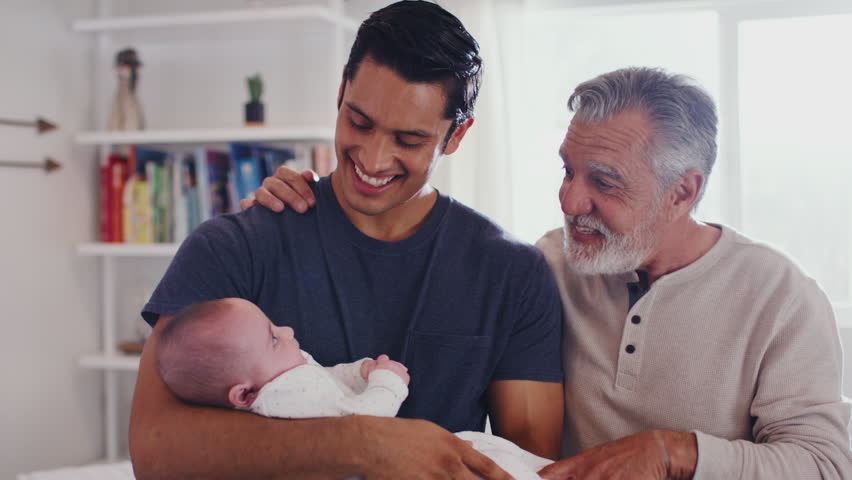 Proud Hispanic father holding his four month old son at home, with grandfather beside them, close up Royalty-Free Stock Footage #1024667303