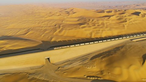Aerial view of a long train crossing vast desert, U.A.E