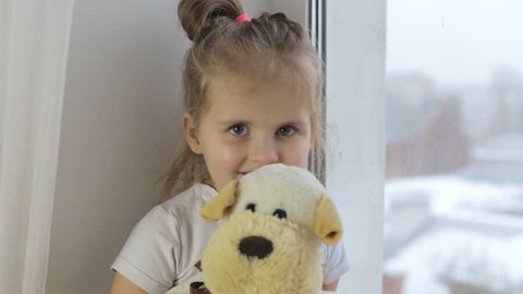 Little girl holding a toy and looking into the camera