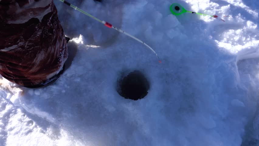 winter fishing, fishing pole hovering over the hole