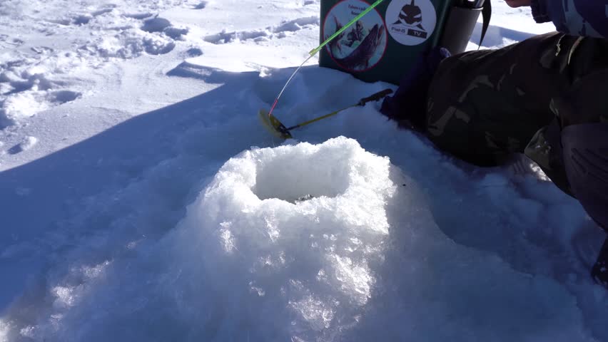 winter fishing, fishing pole hovering over the hole