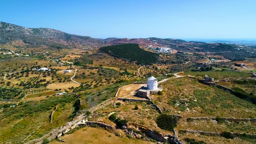 Aerial view of beautiful landscape with mountains and windmill under blue sky