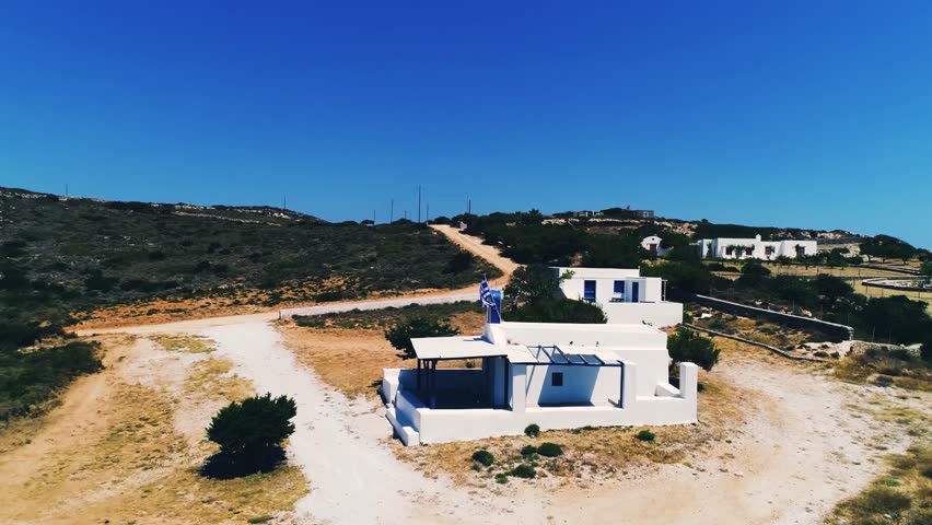 Aerial view of traditional greek church on the hill under blue sky
