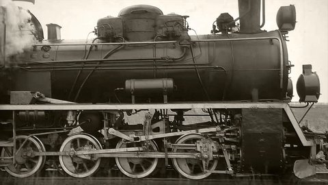 Old passangers train running on the tracks. Retro locomotive with steam engine loopable black and white footage.