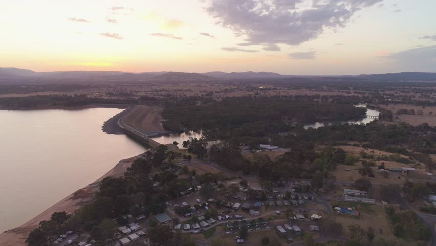 Aerial descend facing Lake Hume Dam at sunset