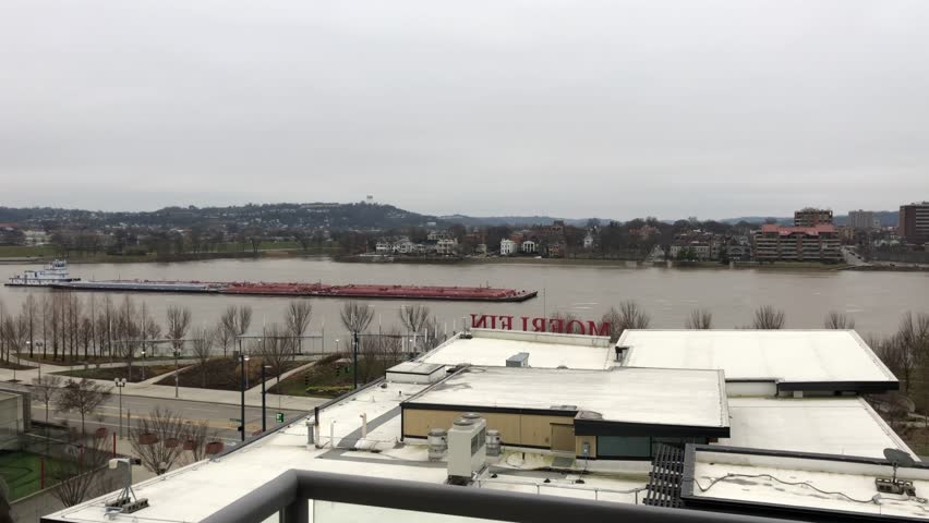 Barge traveling down the Ohio River from a hotel room balcony in downtown Cincinnati, Ohio. The Kentucky city of Covington is in the background.