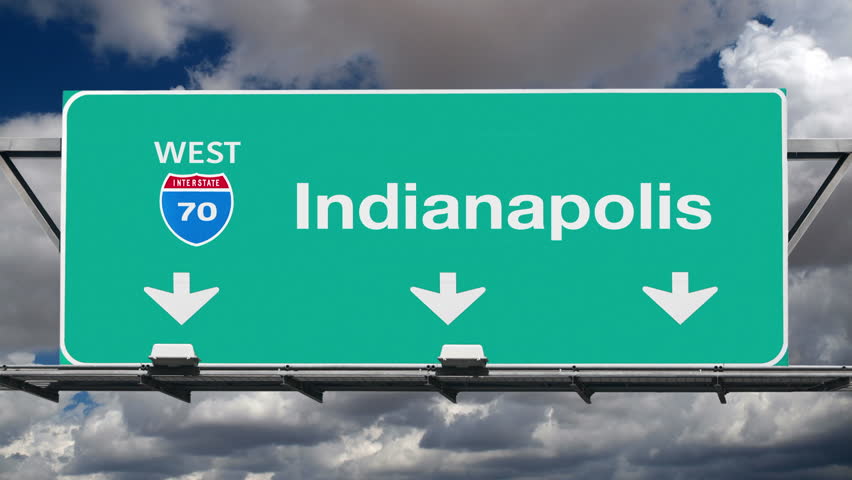 Indianapolis Indiana interstate route 70 overhead freeway directional arrow sign with time lapse clouds.