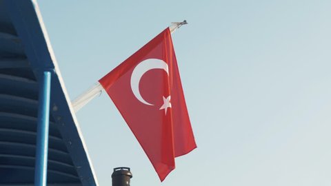 Mytilene, Greece - 08 15 2018: Turkish flag on stern ferry blowing in breeze