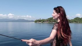 Lifestyle video of pretty travel woman sitting in a filipino boat boat near tropical island . Explore and vacation concept. Port Barton / El Nido / Philippines