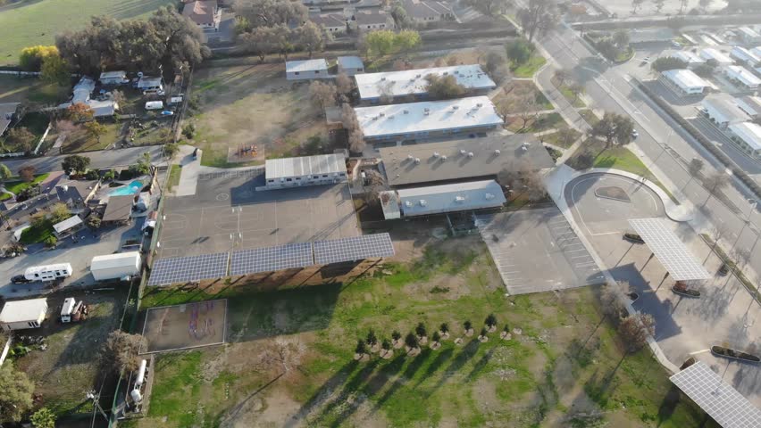 Fly-over of a central Californian town with a school, courts, soccer fields, and a park below