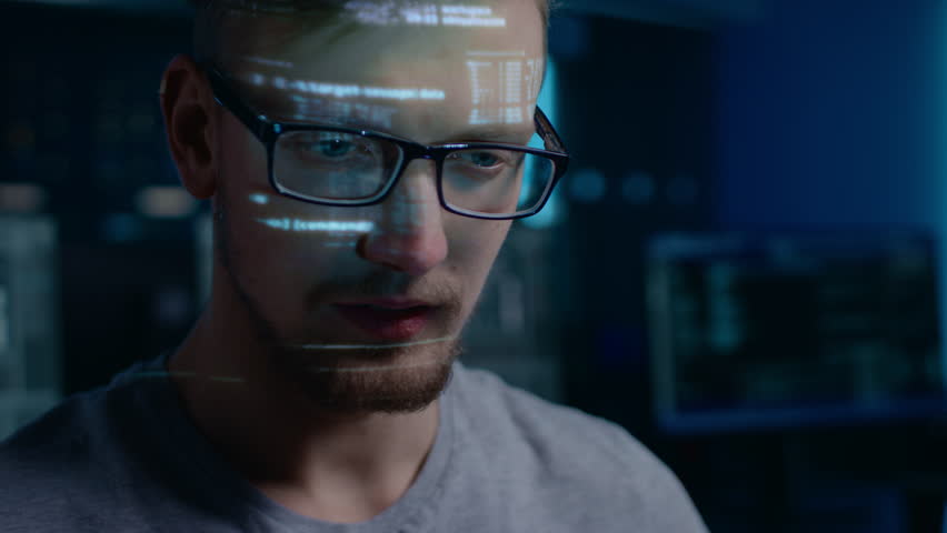 Portrait of Software Developer Hacker wearing Glasses Working on Computer, Projected Code Numbers and Characters Reflect on His Face. Dark Room Full of Technology. Zoom in Shot Royalty-Free Stock Footage #1024746515