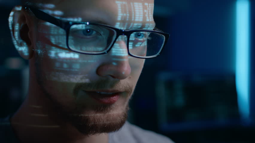 Portrait of Software Developer Hacker wearing Glasses Working on Computer, Projected Code Numbers and Characters Reflect on His Face. Dark Room Full of Technology. Zoom in Shot | Shutterstock HD Video #1024746515