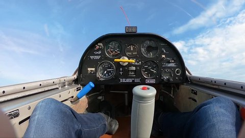 looping in a sailplane, stopping in mid air and then flying down headfirst above fields and forests, pilot's point of view from a cockpit