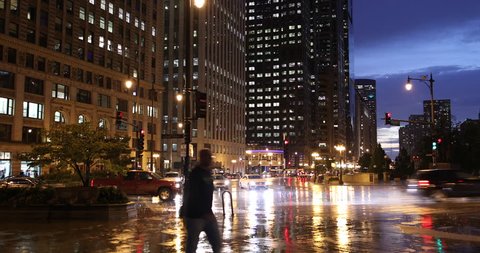 Chicago, Illinois, USA - September 25, 2018: Cars and people walk on the sidewalk along Wacker Drive in downtown Chicago Illinois USA during a rainy night