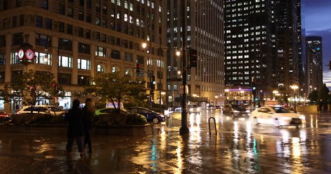 Chicago, Illinois, USA - September 25, 2018: Cars and people walk on the sidewalk along Wacker Drive in downtown Chicago Illinois USA during a rainy night