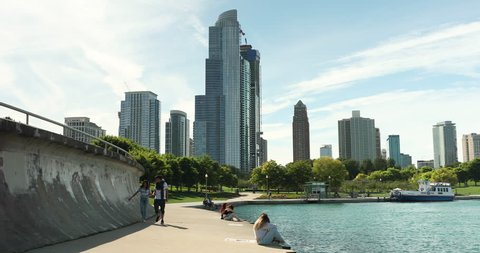 Chicago, Illinois, USA - September 21, 2018: People rest in a park along the Lakefront Trail looking over Lake Michigan and the Chicago downtown city skyline in Illinois USA