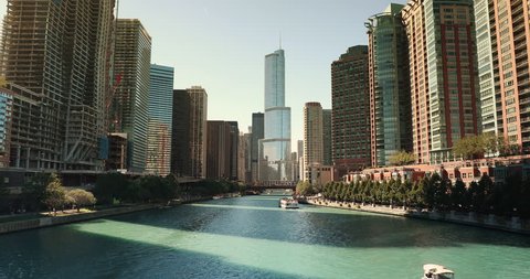 Boats float down the Chicago River skyline in downtown Chicago Illinois USA