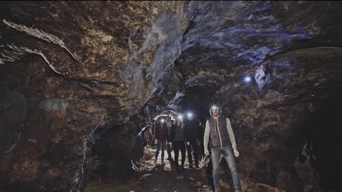Tourists led by a guide in an underground tunnel