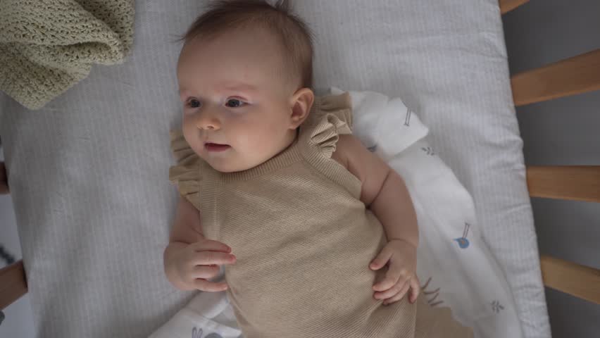 A four-month-old child is very happy. The kid laughs and smile.