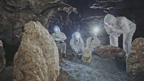 Group of scientists examining a crystal in a cave