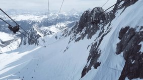 4k video with panoramic view of skiers and cable car seen from the top of Marmolada peak, the highest mountain peak of the Dolomites range.