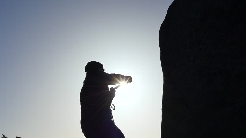 man in hoodie hits the stone rock with pickaxe slow motion silhouette