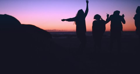 Group of friends dancing on the beach at dusk slow motion silhouette RED DRAGON