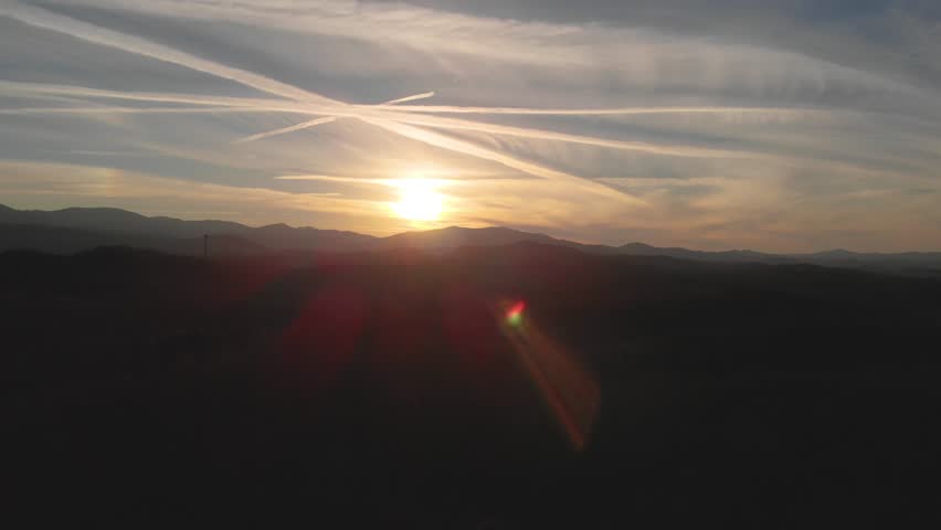 An epic view of the Smoky Mountains at Sunset. the shot is exposed for the sun, leaving a silhouette of the ridge visible as camera dollies towards the sun.