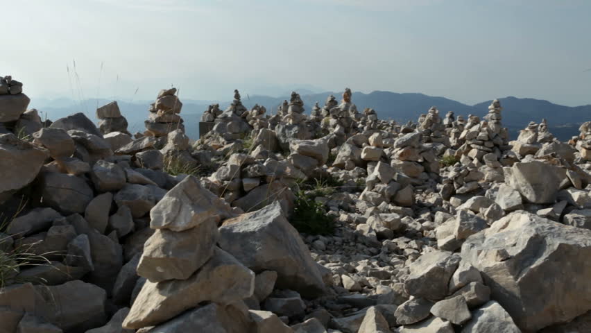 Stacked rock towers on mountain top for meditation, worship, remebrance or other spiritual purposes - camera pan