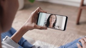 young woman having video chat using smartphone at home chatting to mother enjoying conversation sharing lifestyle on mobile phone