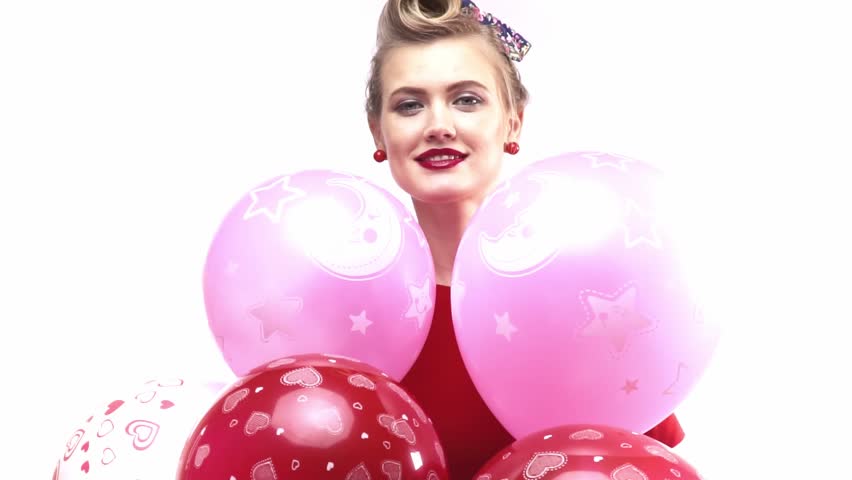 Happy blonde girl in red dress with lots of colorful balloons