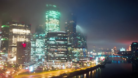 Amazingly beautiful hyperlapse of Moscow City Business Center on the foggy night with glittering lights from buildings, streets and traffic. Close up aerial shot. 8K ultra high definition footage.