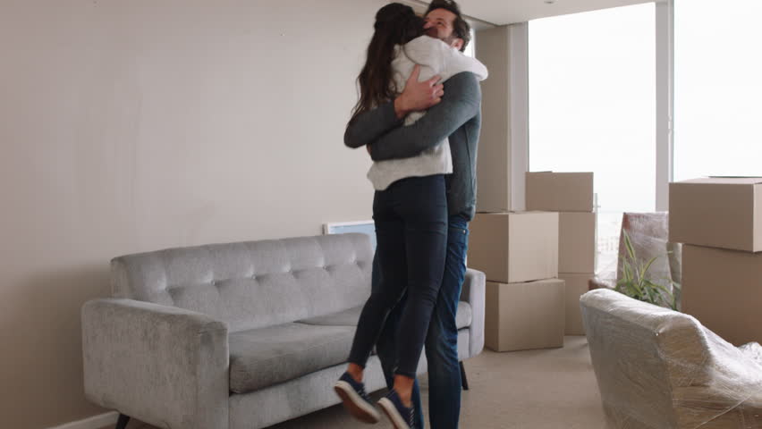 Young couple moving house new home owners smiling enjoying successful move hugging in apartment | Shutterstock HD Video #1024808069