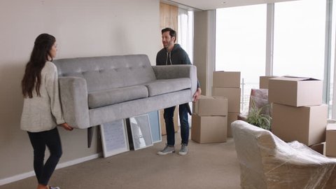 young couple moving house new home owners smiling enjoying successful move hugging in apartment