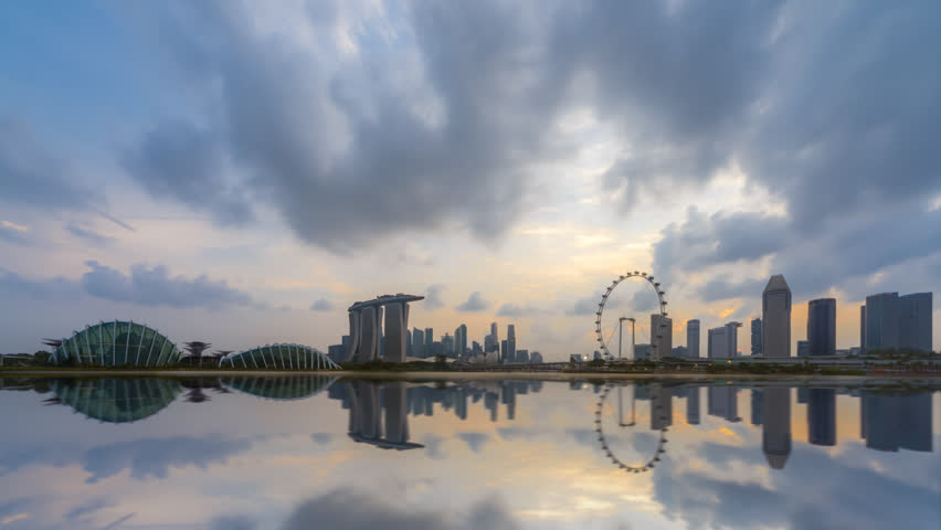 Time lapse of Day to Night of Singapore city skyline by a river at dusk with reflection. Pan down motion timelapse. 4K available. Royalty-Free Stock Footage #1024812926
