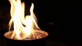The fire that burns in the bowl, slow motion. yellow-white fiery tongue. Cozy warm pleasant background