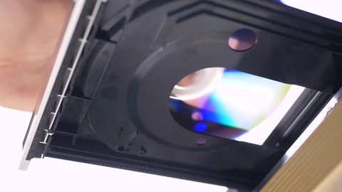 Hand insert DVD CD to dvd player at white background