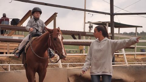 Therapeutic riding trainer with young kid shot