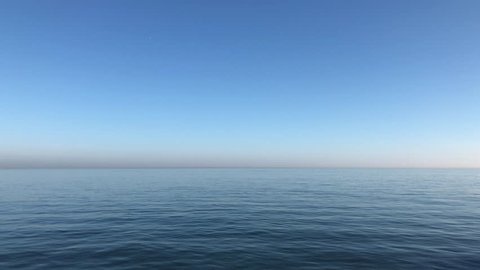 Video of calming waves of the North Sea/Ocean during a warm sunny morning with a blue cloudless sky at Roker Pier, Sunderland, Tyne and Wear, England UK.